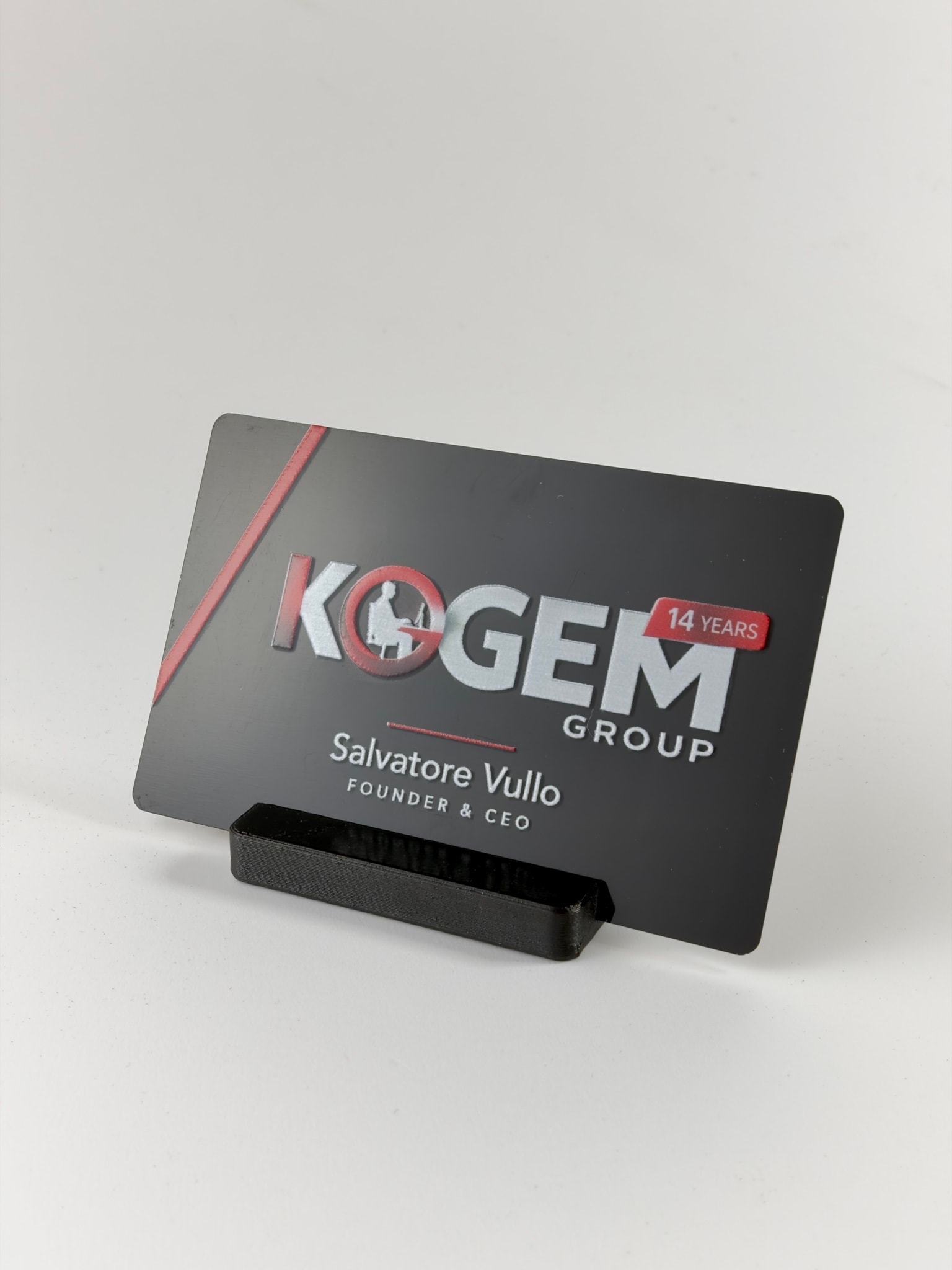 Fronte del biglietto in metallo nero con logo Kogem Group in bianco e rosso