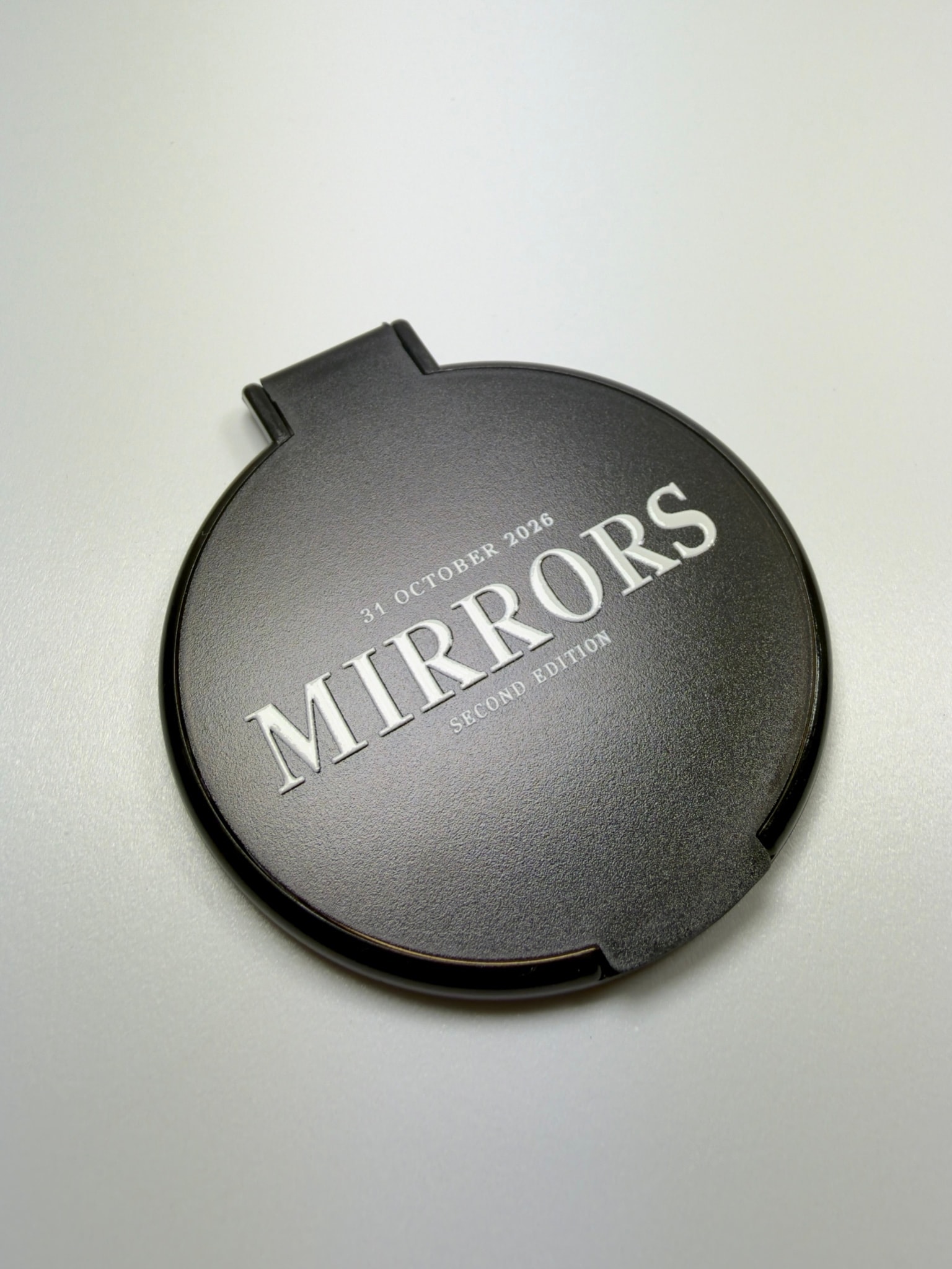 Specchietto nero con scritta MIRRORS in bianco, visto dall'alto
