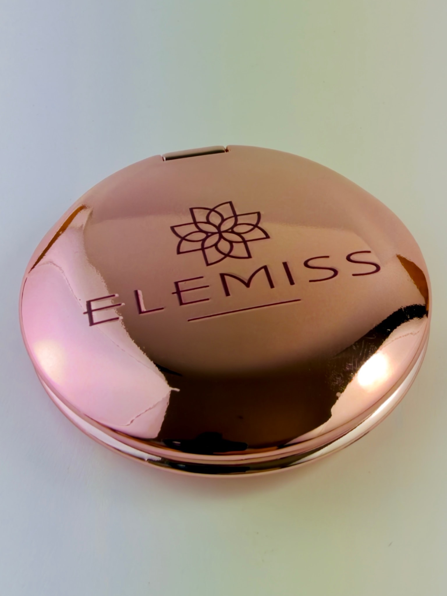 Primo piano del coperchio rosa metallizzato: il logo Elemiss resta nitido anche sui riflessi
